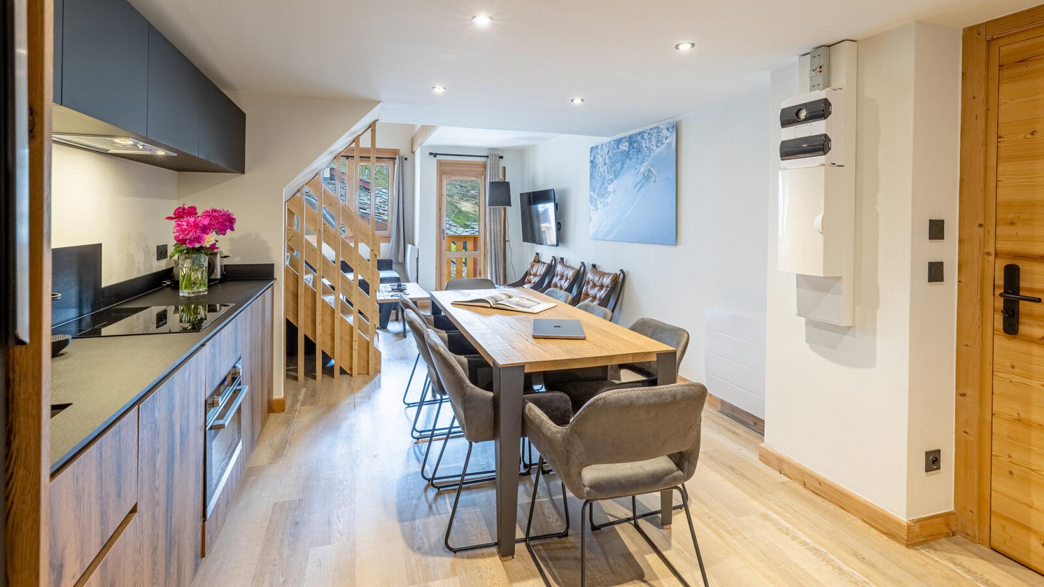 Grande pièce de vie avec cuisine, table à manger et escalier d'un duplex de la Résidence Cassiopée